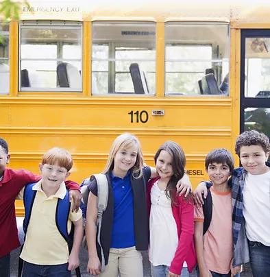 A group of children standing in front of a school bus.