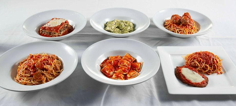 A table with several bowls of food on it.