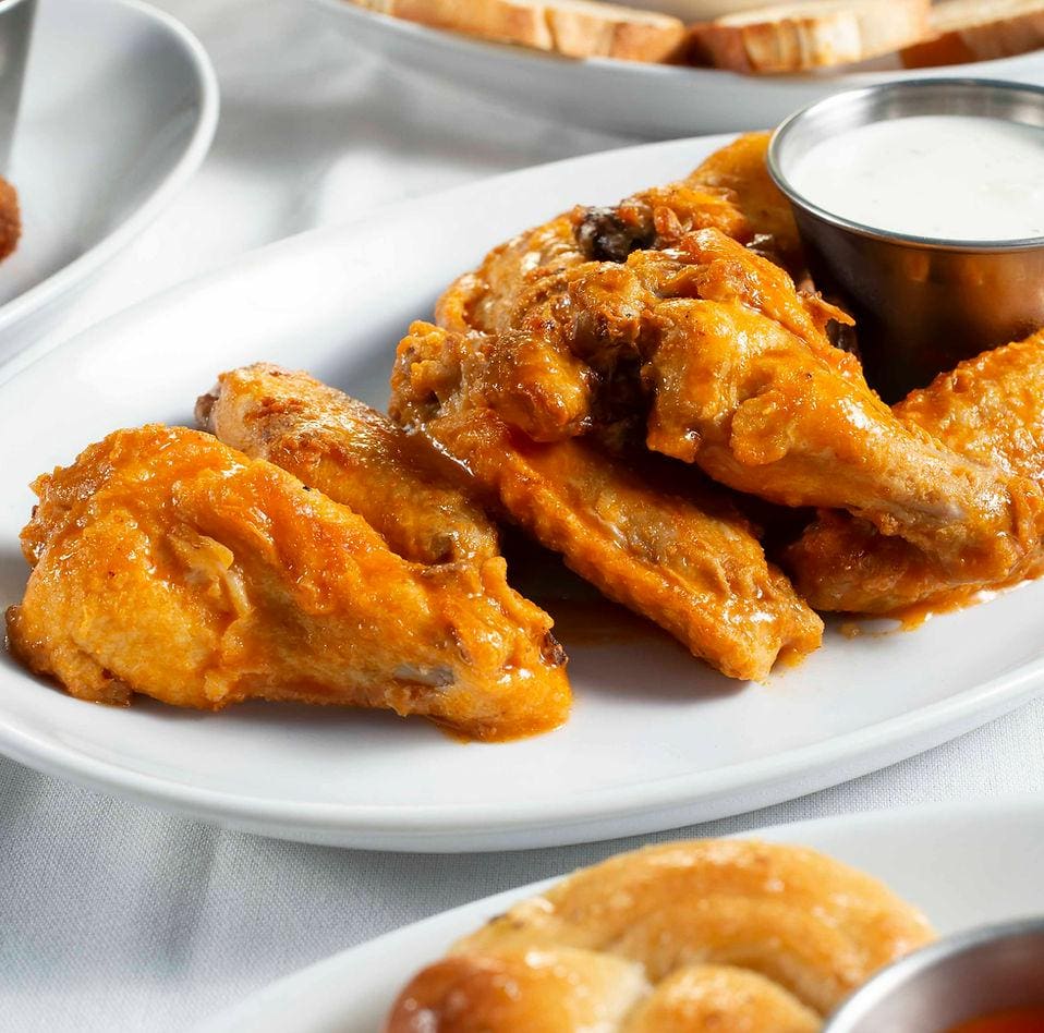 A plate of chicken wings with dipping sauce.