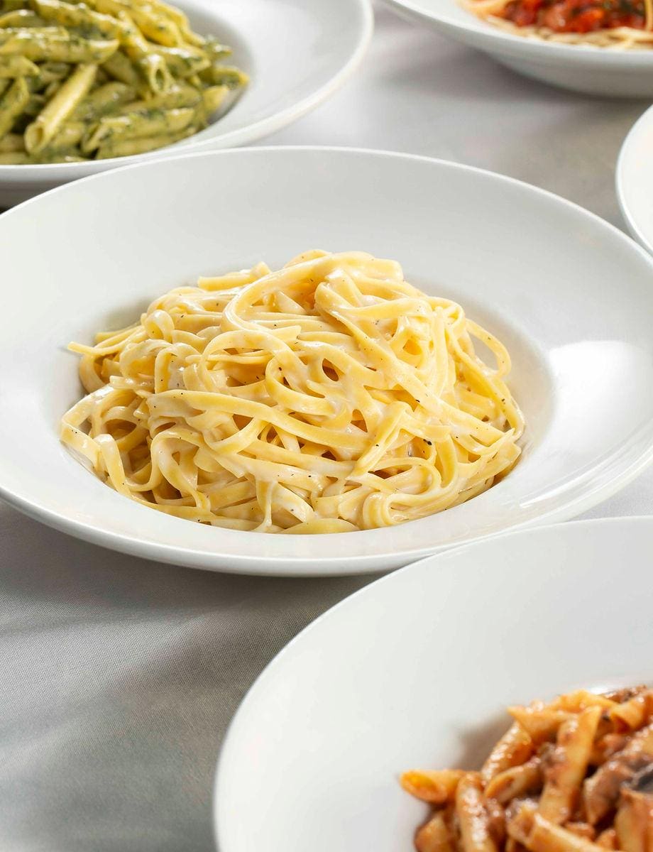 A bowl of pasta sits on the table.