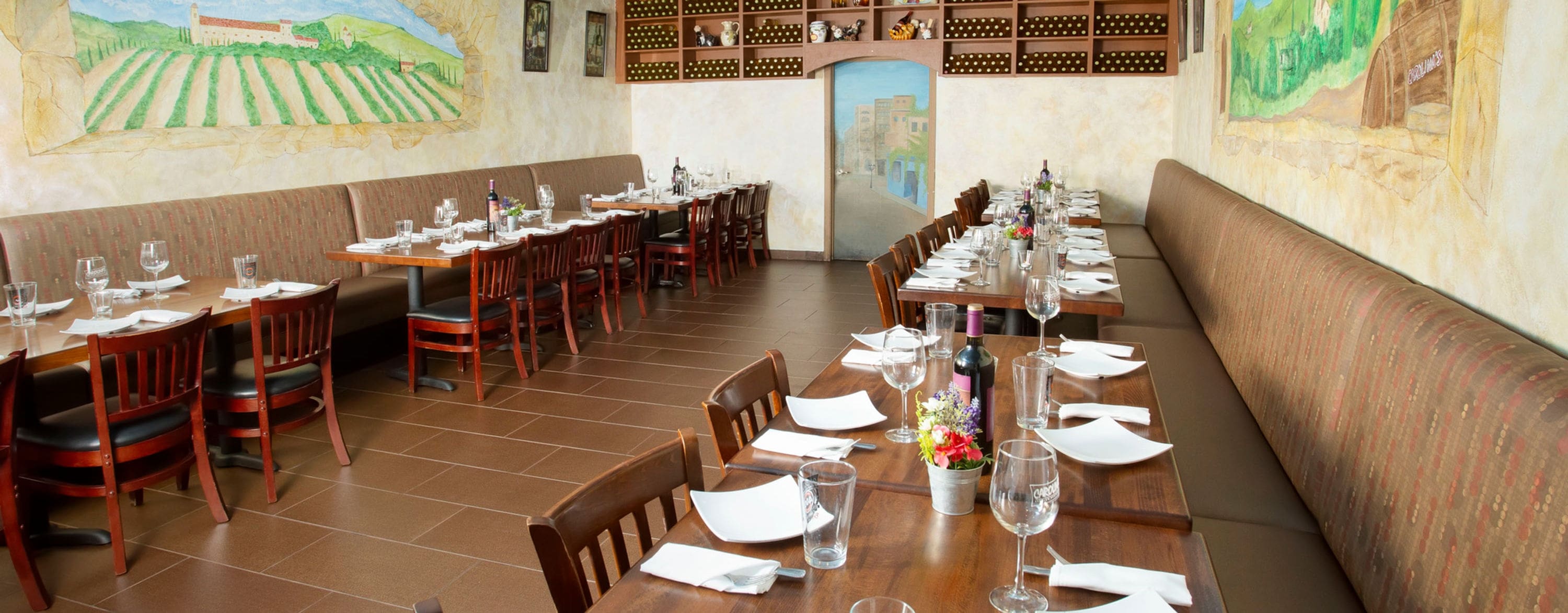 A restaurant with tables and chairs set up for dinner.