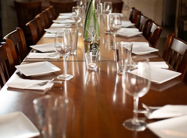 A long table with wine glasses and napkins on it