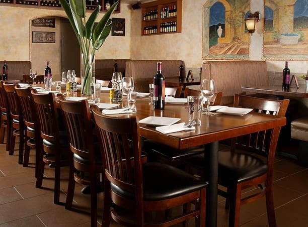 A restaurant with tables and chairs set up for dinner.