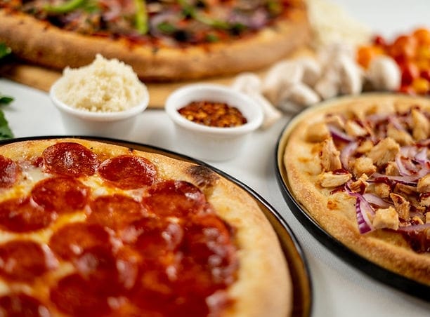 A table topped with different types of pizzas.